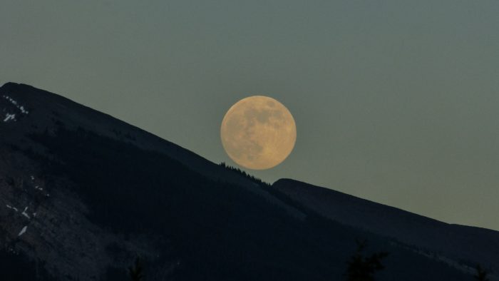 A large full moon above the mountains