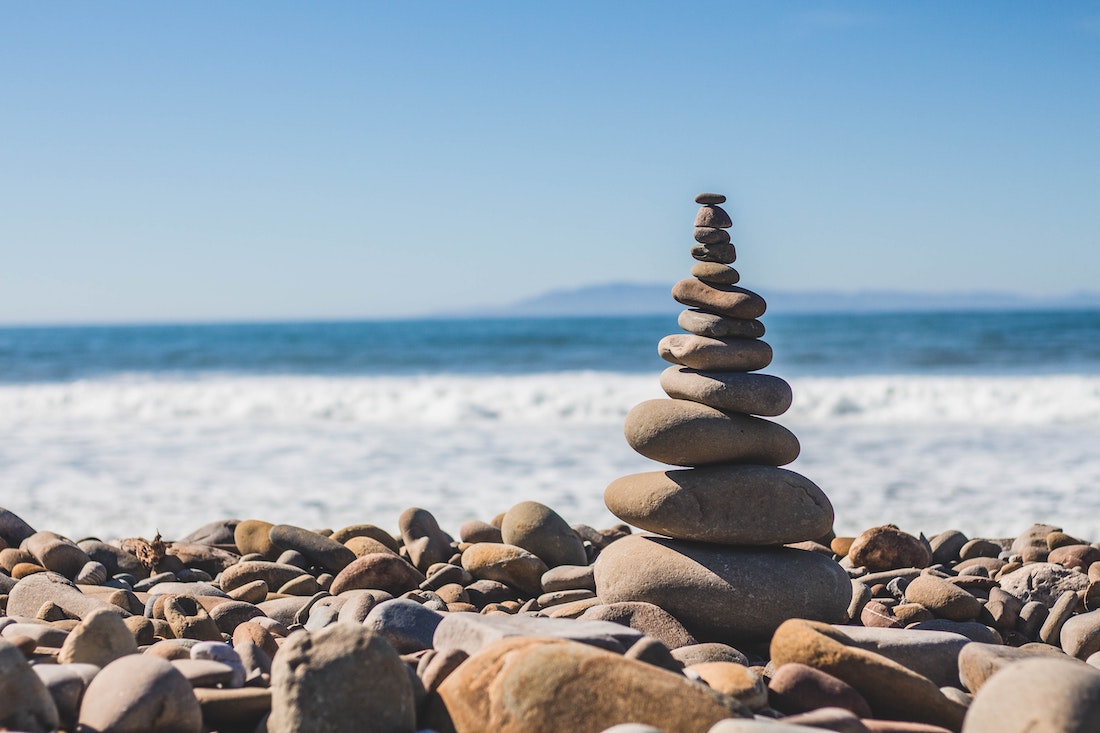 a tower of rocks balancing near the ocean
