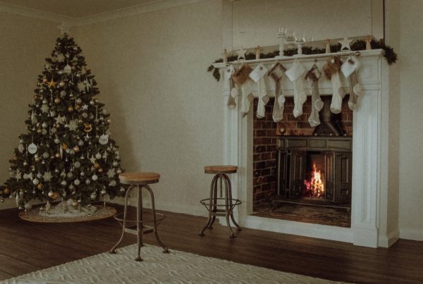 stockings hung by an open fire, a christmas tree sits in the corner